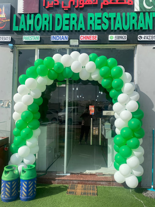 white and green colour balloon arch
